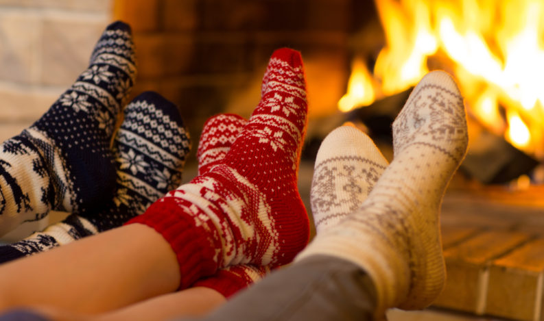 Family in socks near fireplace in winter or christmas