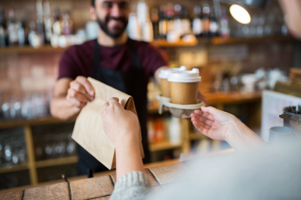 small business, people and service concept - man or bartender serving customer at coffee shop