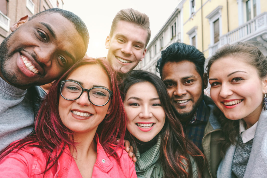 Happy members from credit unions and races taking selfie with back lighting - Youth and friendship concept with young people having fun together - Main focus on left two guys